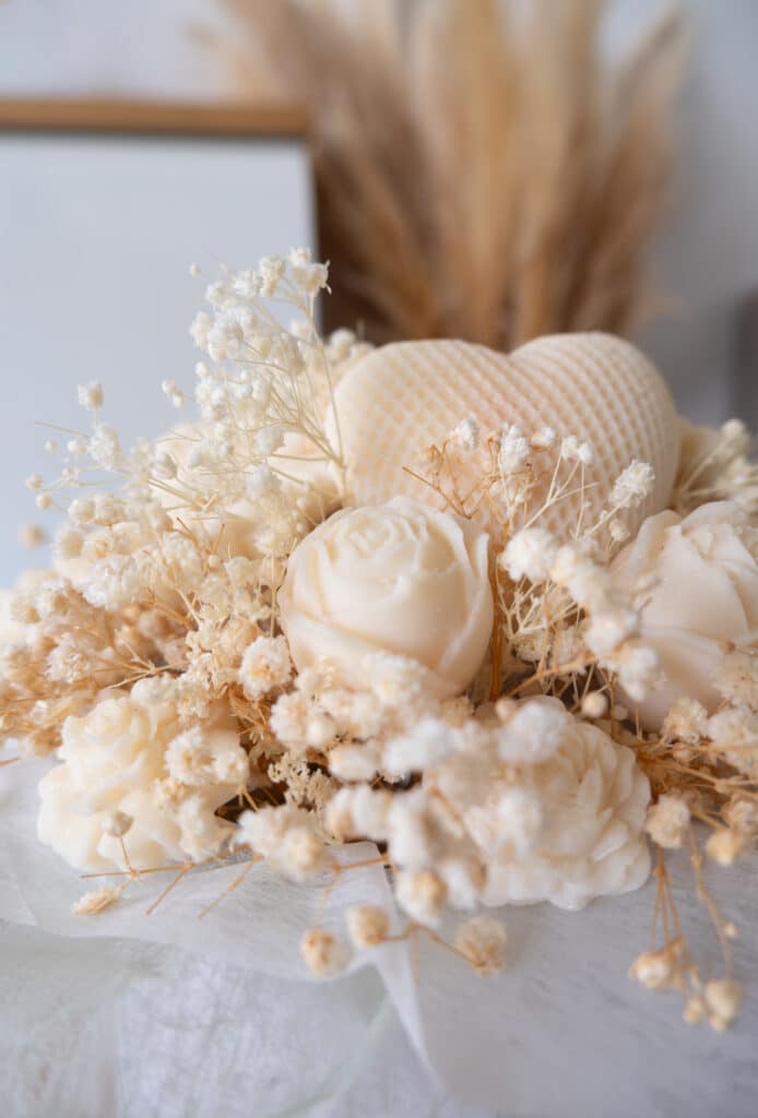 Bougies Roses et Cœur avec Fleurs Séchées Gypsophile Bouquet de bougies en forme de roses et cœur beige entouré de gypsophile séchée pour une décoration douce.